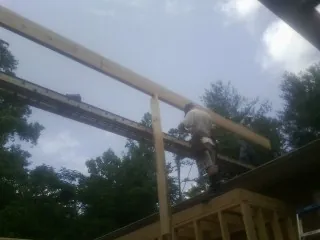 Carpenter setting a ridge beam over a new addition frame — Ice Dam Removal by Roofing Brothers in Stanley