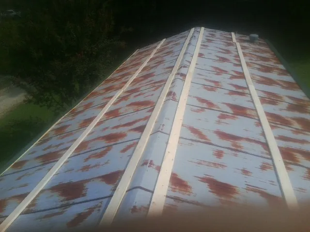 Rusted metal roof panels with new wood purlins before replacement — Storm Damage Roof Repair in Stanley by Roofing Brothers